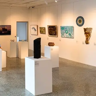 a room with white pedestals and art on the wall