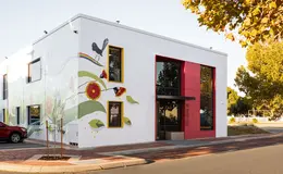 Large white building for young people with flower artwork painted on the exterior