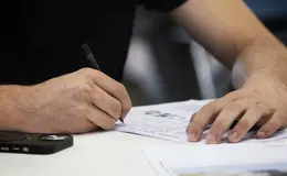 a person writing on a piece of paper