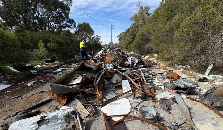 a man standing in front of a pile of debris