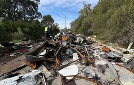 a man standing in front of a pile of debris