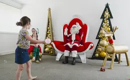 a girl playing with a child in a room with a santa claus
