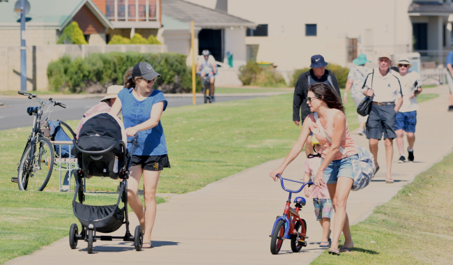 a group of people walking on a sidewalk