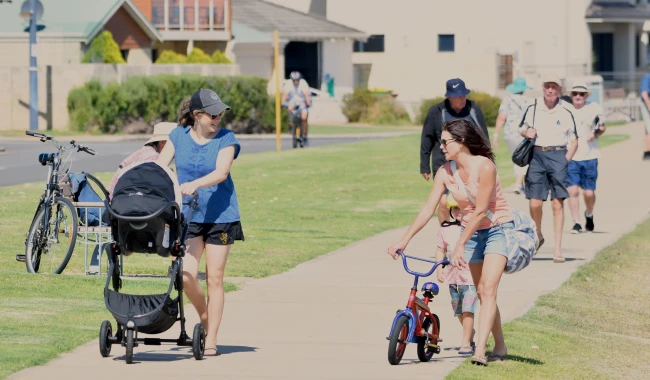 a group of people walking on a sidewalk