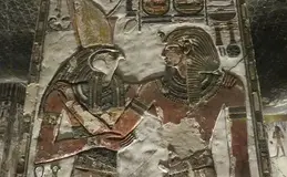 a stone wall with a couple of egyptian gods