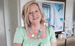 a woman wearing a green shirt and a necklace
