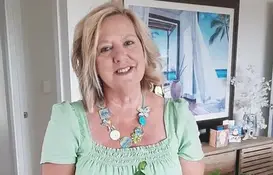 a woman wearing a green shirt and a necklace