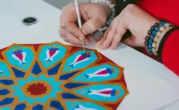 a person painting a pattern on a table