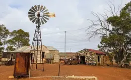 a windmill in a dirt field