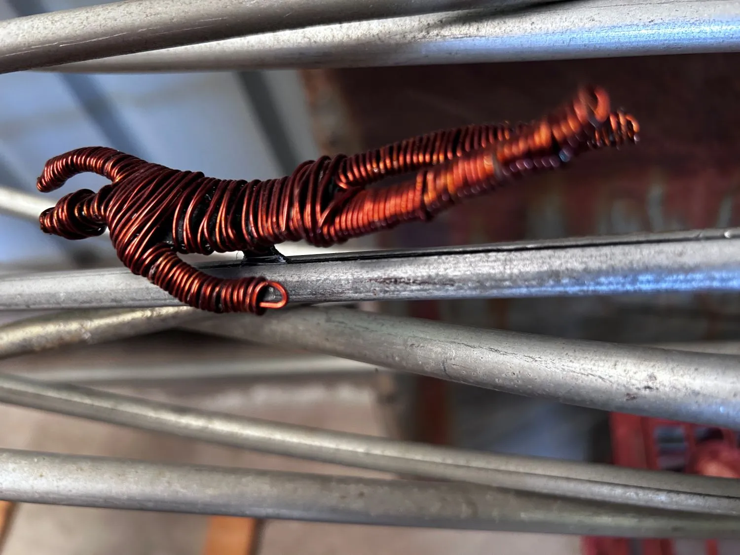 a wire sculpture of a person on metal rods