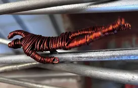 a wire sculpture of a person on metal rods