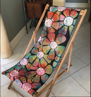 Deckchair decorated with colourful paintings of flowers.