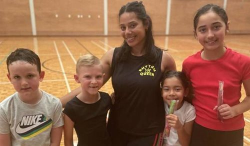A staff member with a group of children at the Aqua Jetty indoor court.