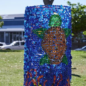 A sea scape sculpture featuring a turtle made from chicken wire, drink bottle lids, recycled plastic, ribbon.