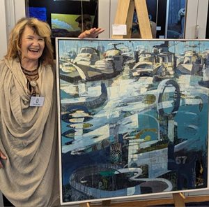 Artist Deb Zibah standing next to an abstract acrylic on panel painting on an easel.