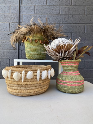 Three textured baskets with dried flowers.