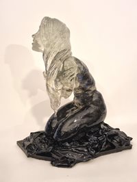 A sculpture of a pelican flying with a fish in its mouth made of recycled materials and installed at the beach