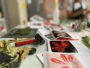 Screenprinting equipment and artwork laid out on a table.